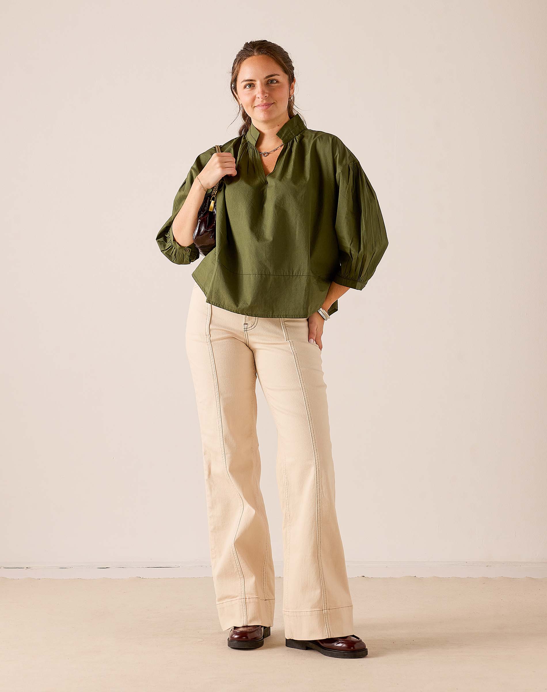 Hazel green puff sleeve top with a gathered waist and relaxed fit.