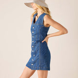 Woman wearing a denim dress with buttons on a beige background