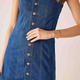 Blue denim dress with buttons on a plain background