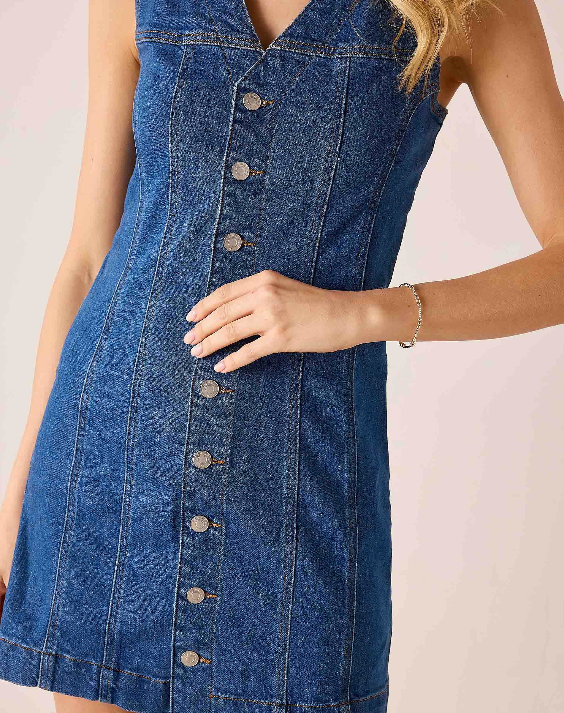 Blue denim dress with buttons on a plain background