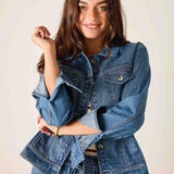 Woman wearing a blue denim jacket against a plain background