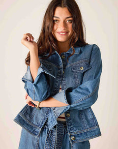 Woman wearing a blue denim jacket against a plain background
