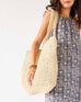 woman holding sun chaser large tote with blue dress on