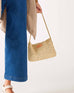 close up image of woman holding sun chaser straw pochette