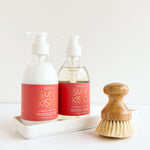 sun kissed liquid hand soap shea lotion and brush laying on a white background with tray