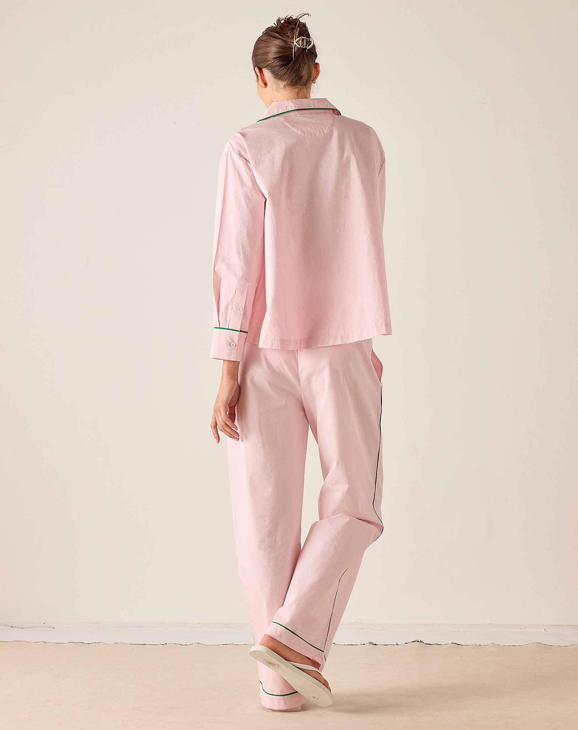 Person wearing a pink pajama set with a white background