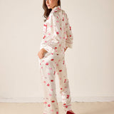 Woman wearing a pajama set with red lip prints on a white background