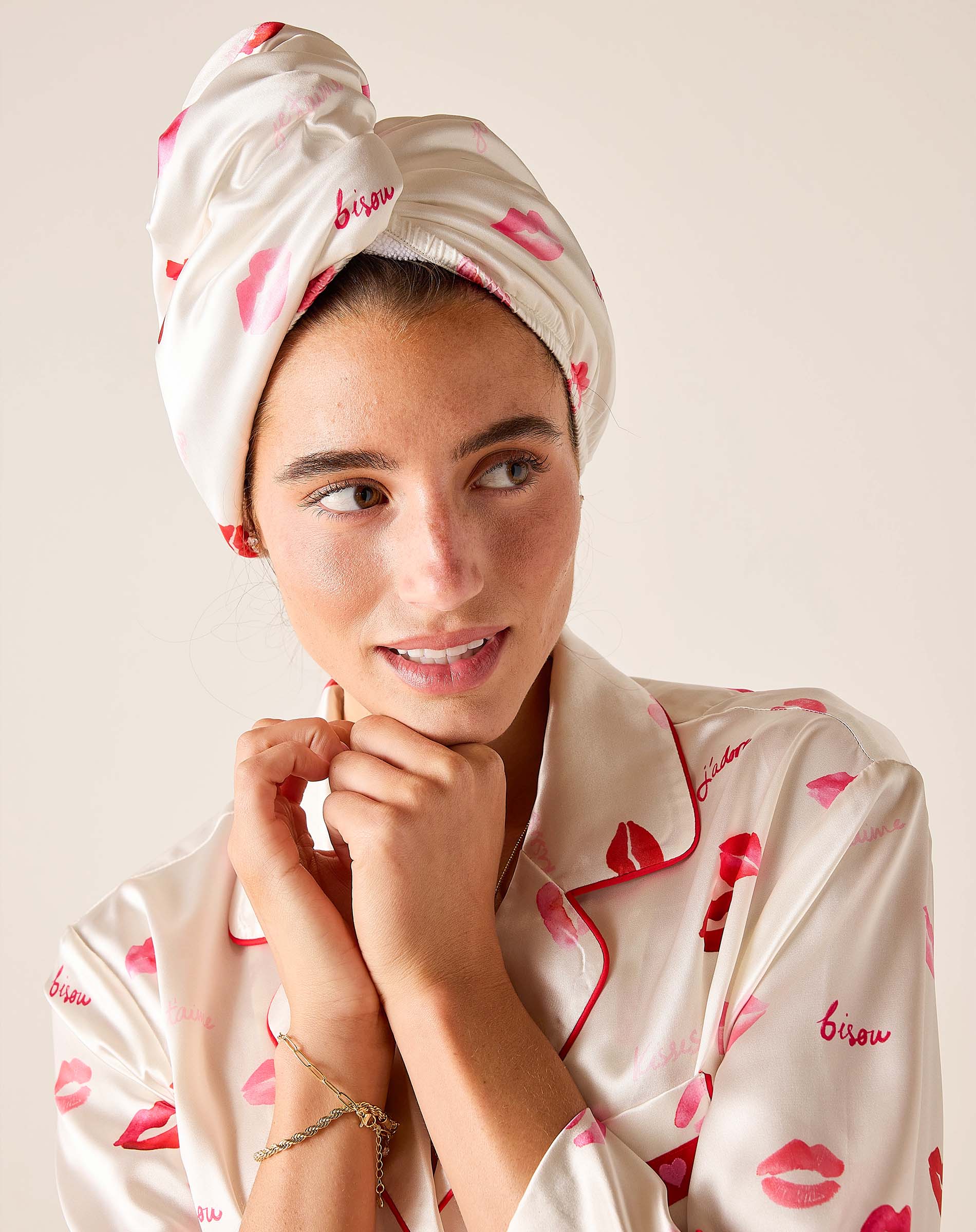 Woman wearing a matching headscarf and pajama set with lip print design on a plain background