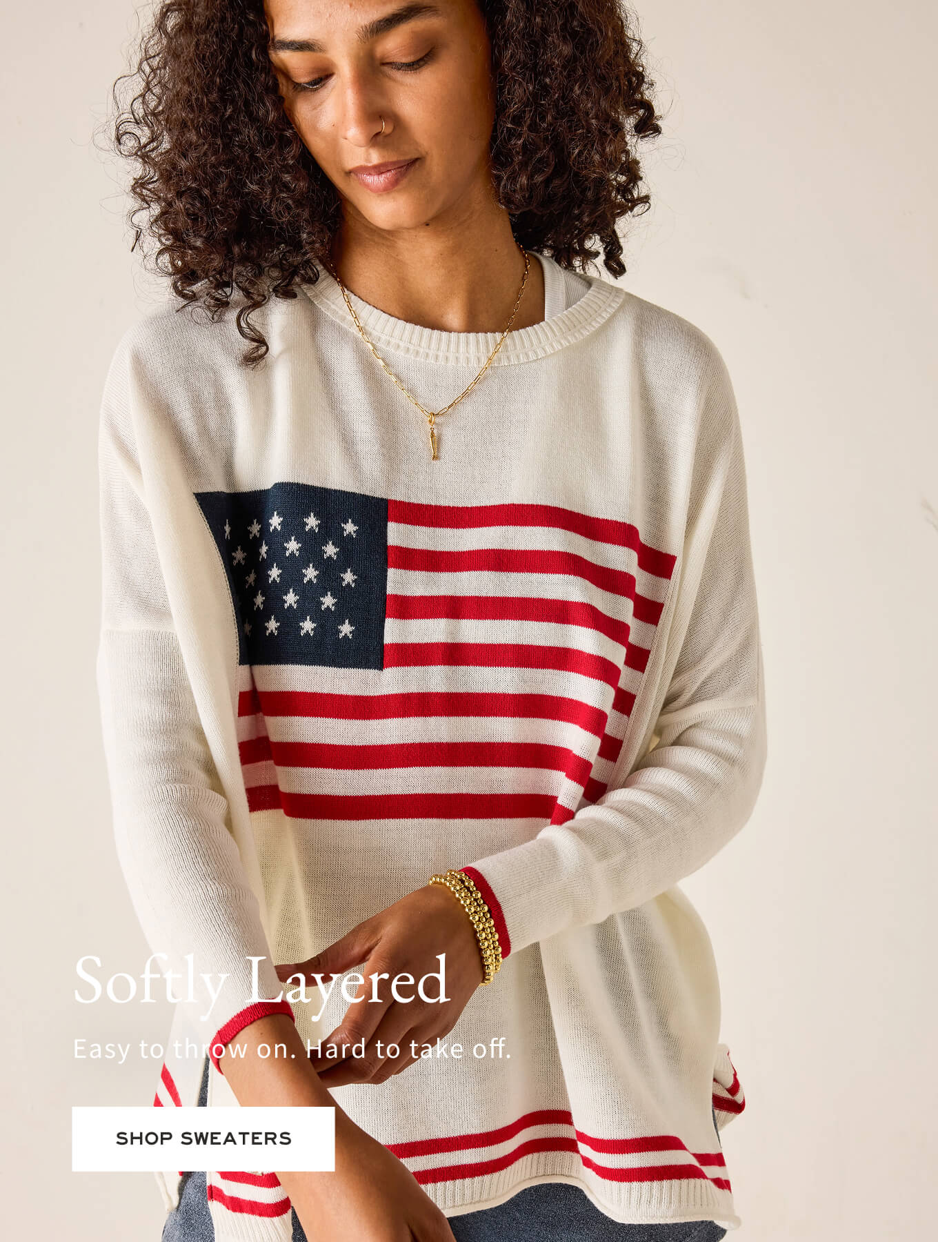 Woman wearing a sweater with an American flag design on a beige background