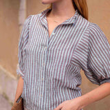 Woman wearing a striped shirt with a neutral background
