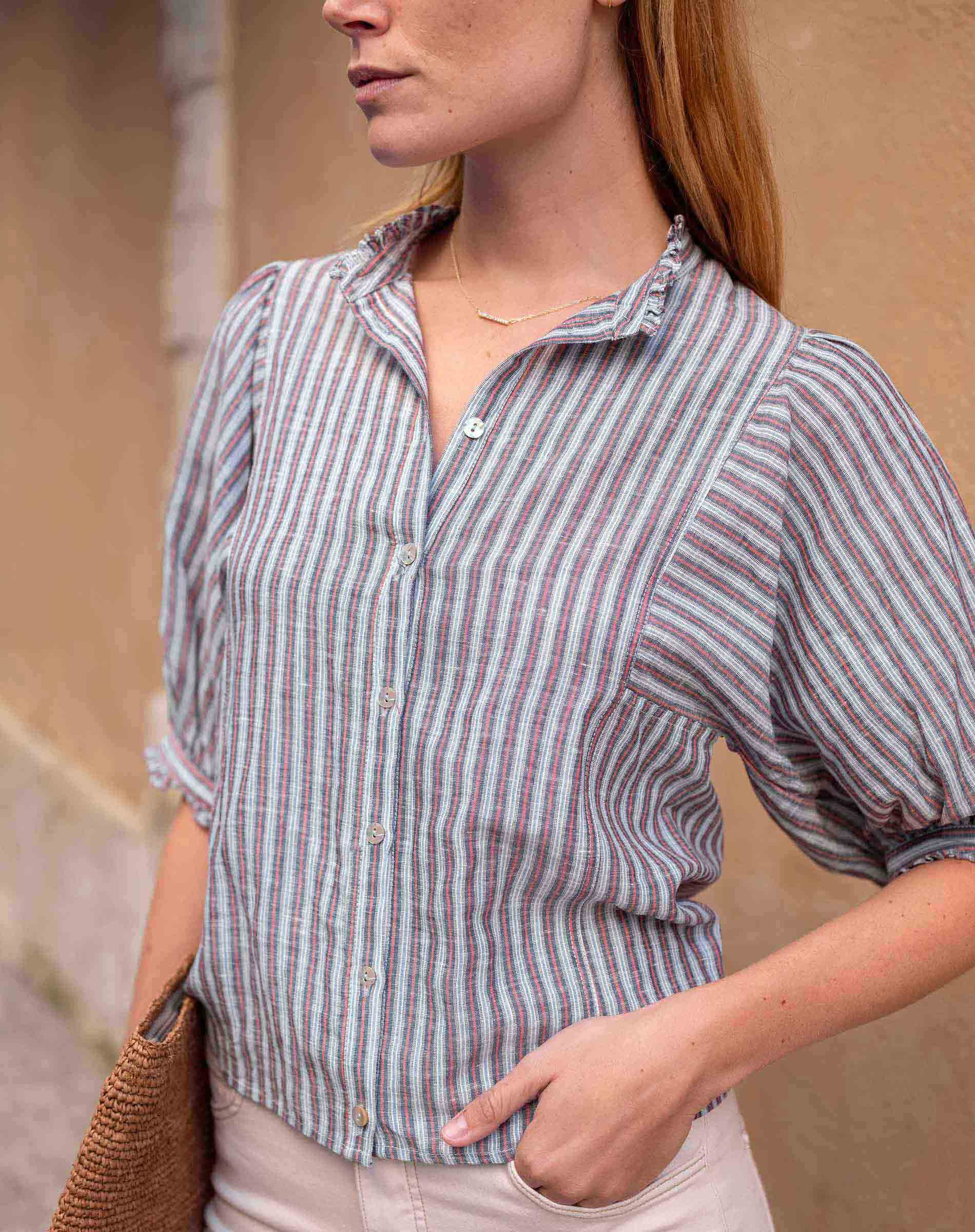 Woman wearing a striped shirt with a neutral background