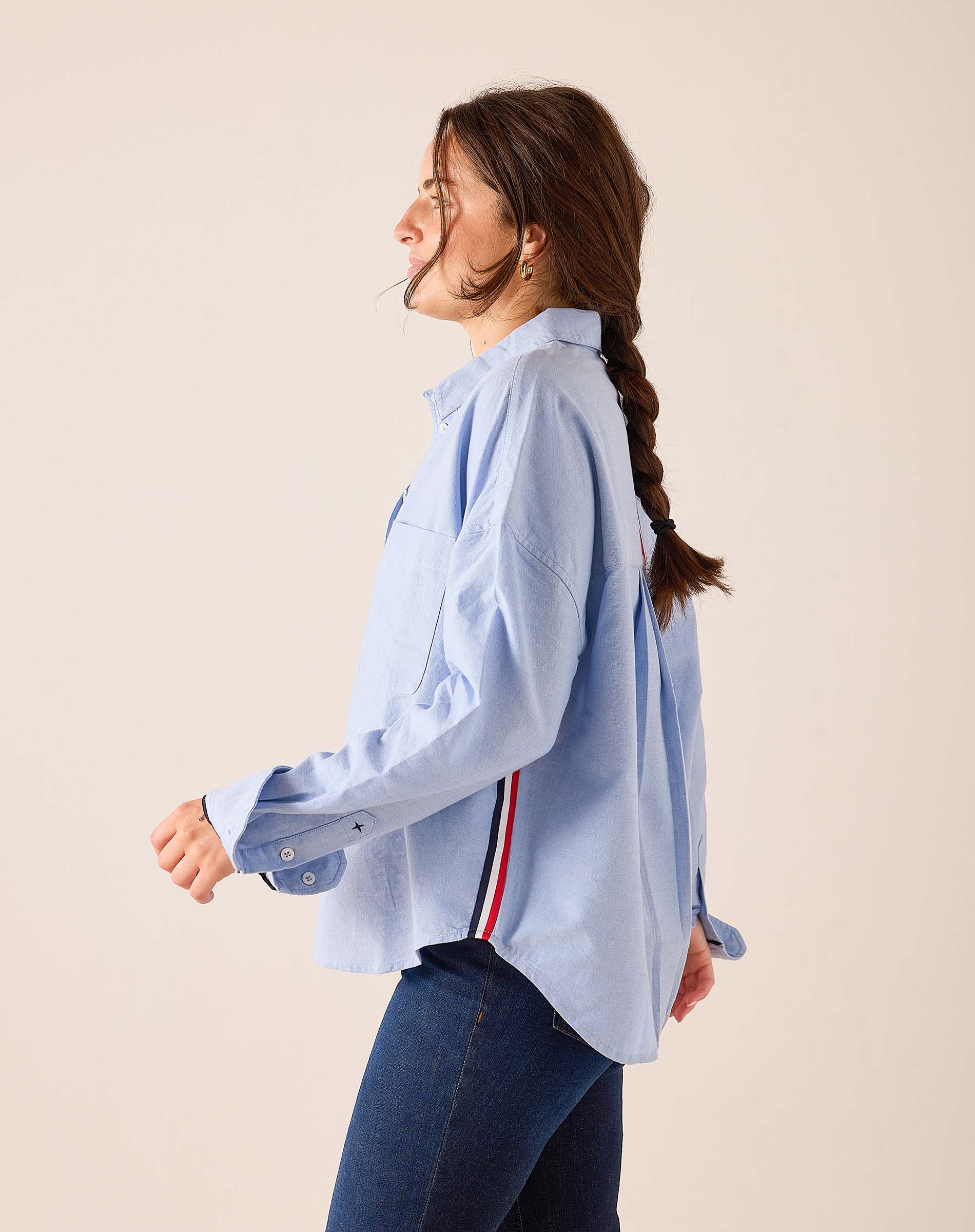 Oxford blue oversized button-up shirt with a navy and red stripe detail on the back