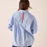 Back view of women's travel-friendly Oxford blue button-down shirt featuring a striped detail on the back yoke.