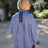 Blue and white striped button-down shirt with a unique back panel detail.