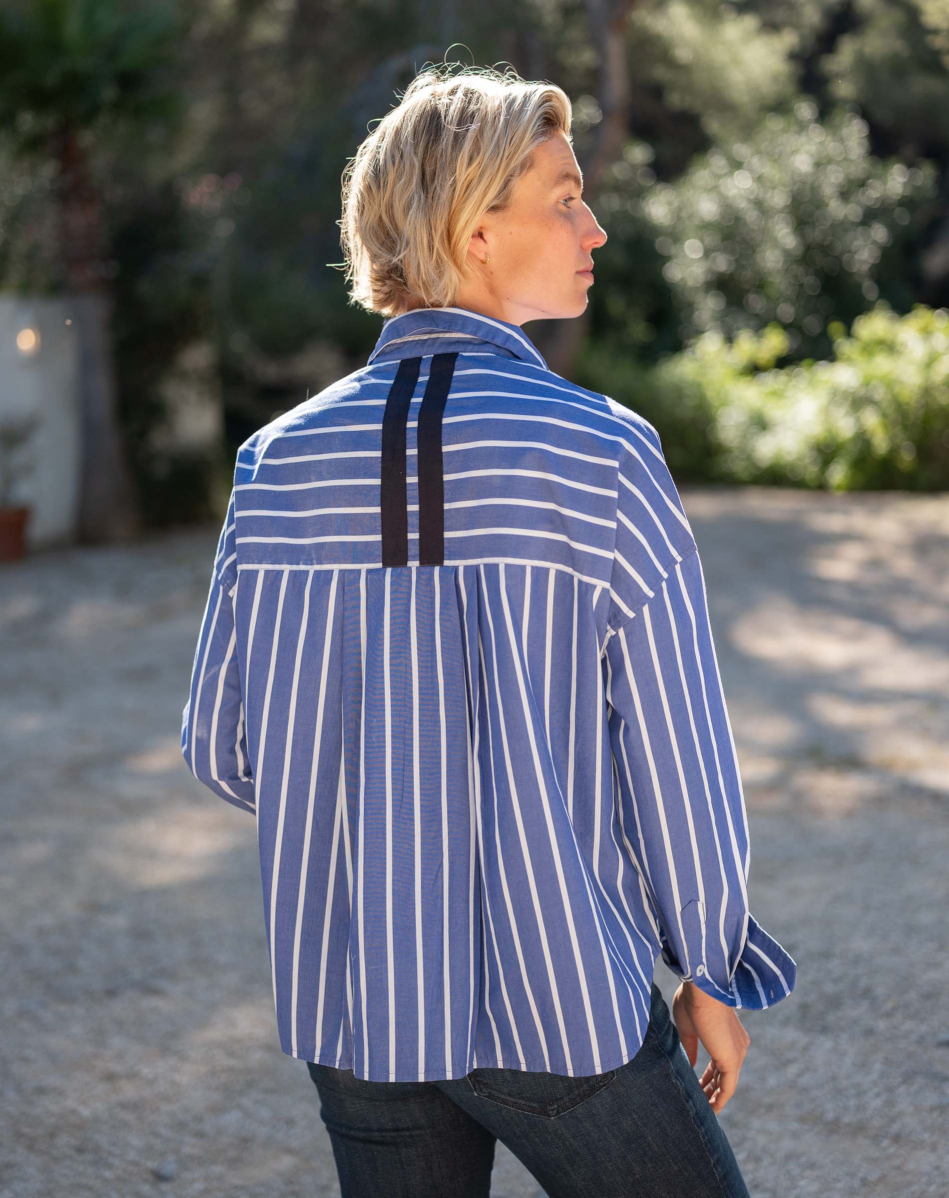 Blue and white striped button-down shirt with a unique back panel detail.