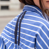 Blue and white striped shirt with black tape detailing on the shoulder