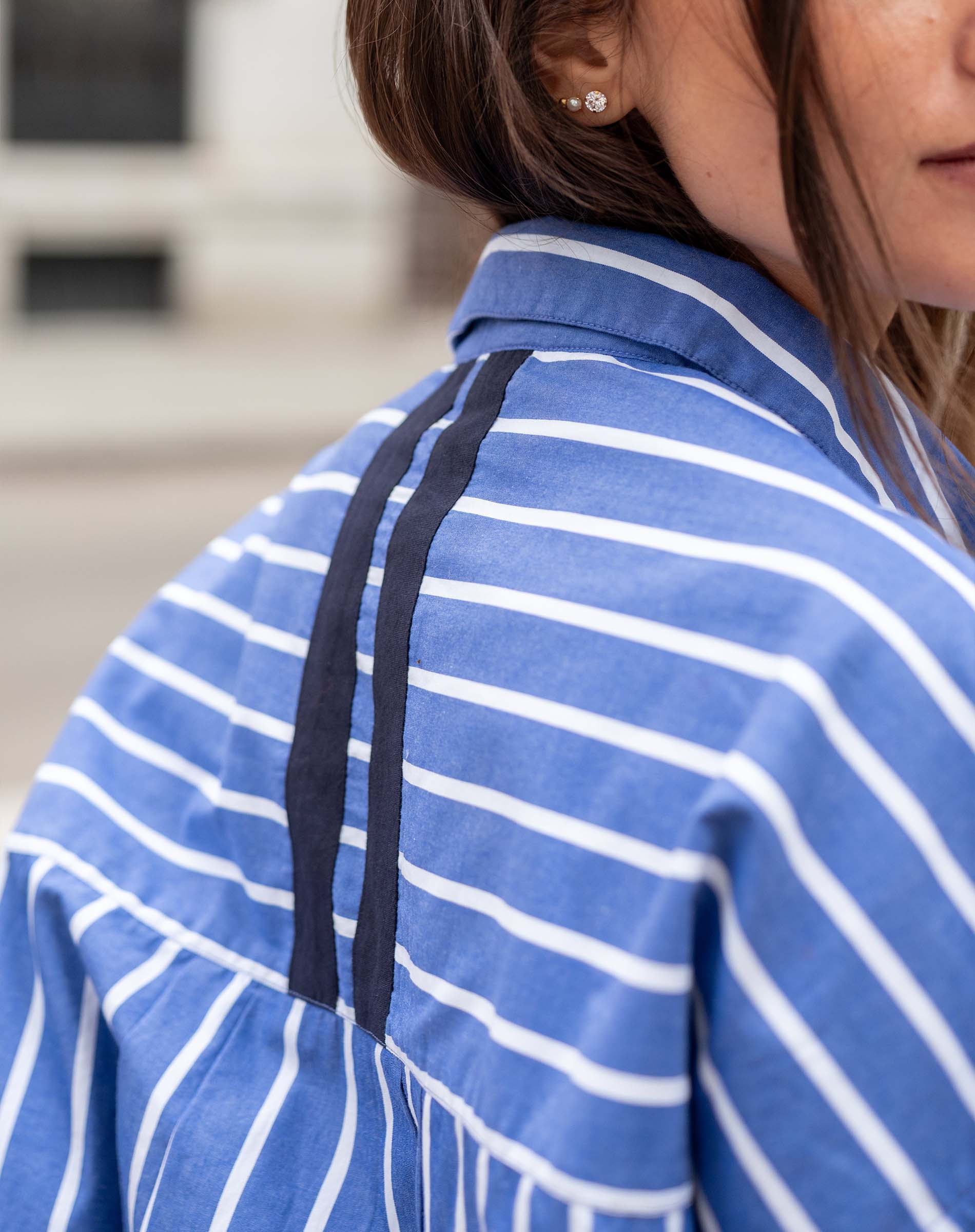 Blue and white striped shirt with black tape detailing on the shoulder