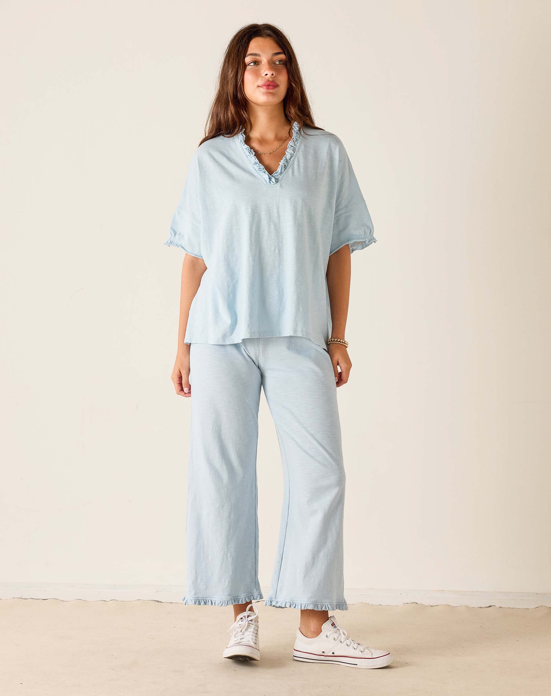 Woman wearing a light blue outfit with a plain background