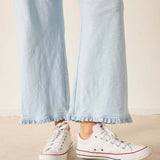 White sneakers with red accents worn with light blue jeans on a beige background