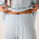 Person wearing light blue pajama set with a neutral background