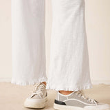 Person wearing white sneakers with a neutral background