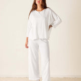 Woman wearing a white outfit with a plain background