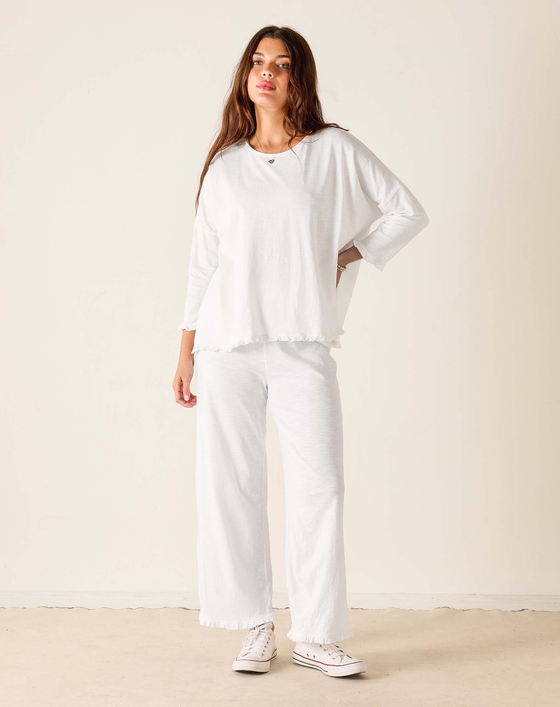 Woman wearing a white outfit with a plain background