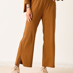 Person wearing mustard yellow pants with a plain background
