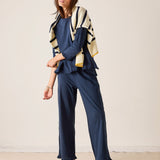 Woman wearing a blue outfit with a striped cardigan against a plain background