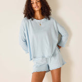 Woman wearing a light blue outfit with a plain background