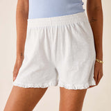 White shorts worn by a person on a beige background