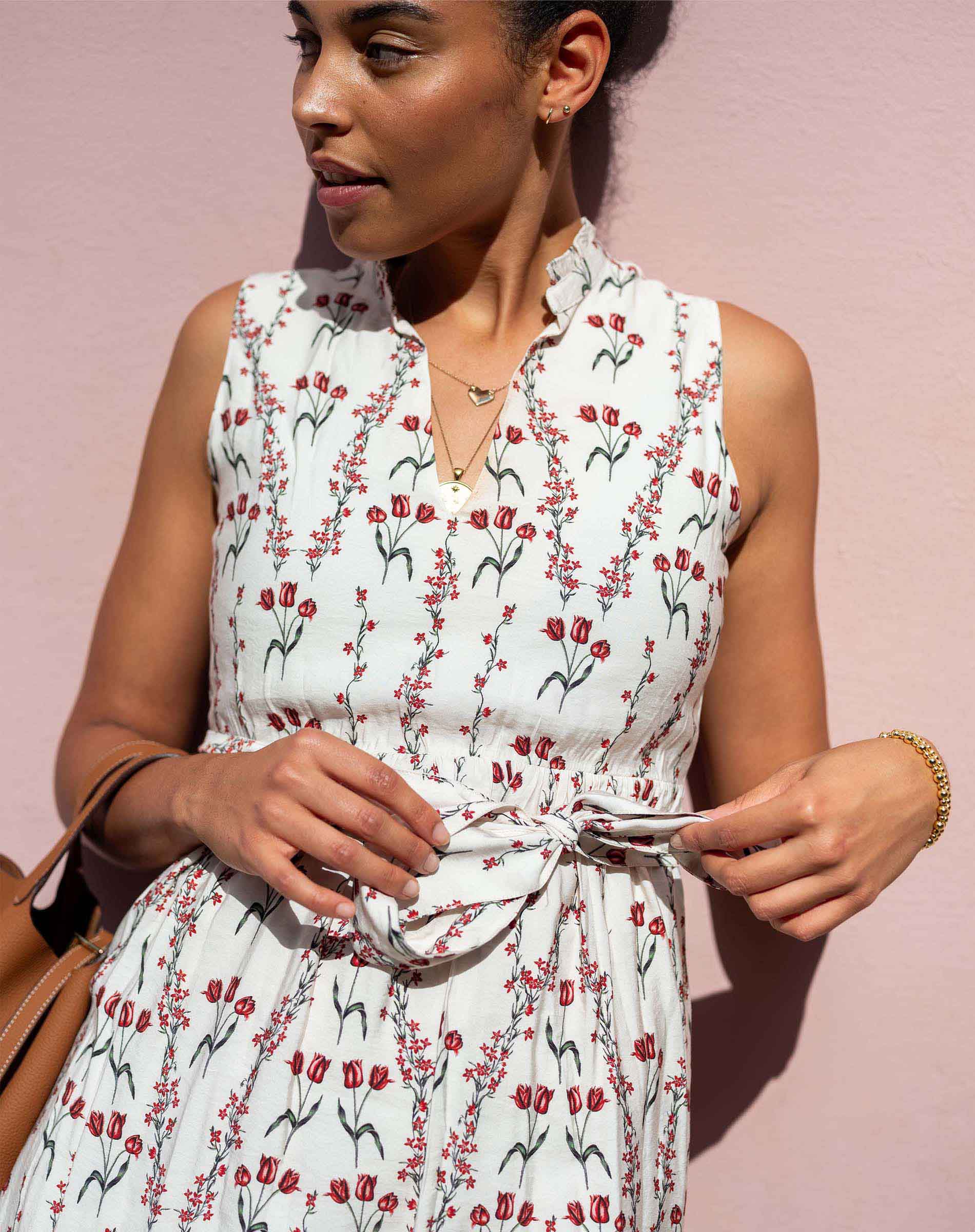 Woman wearing a floral dress against a pink background