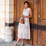 Woman in a floral dress standing against a wooden door