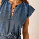 Denim dress worn by a person on a plain background
