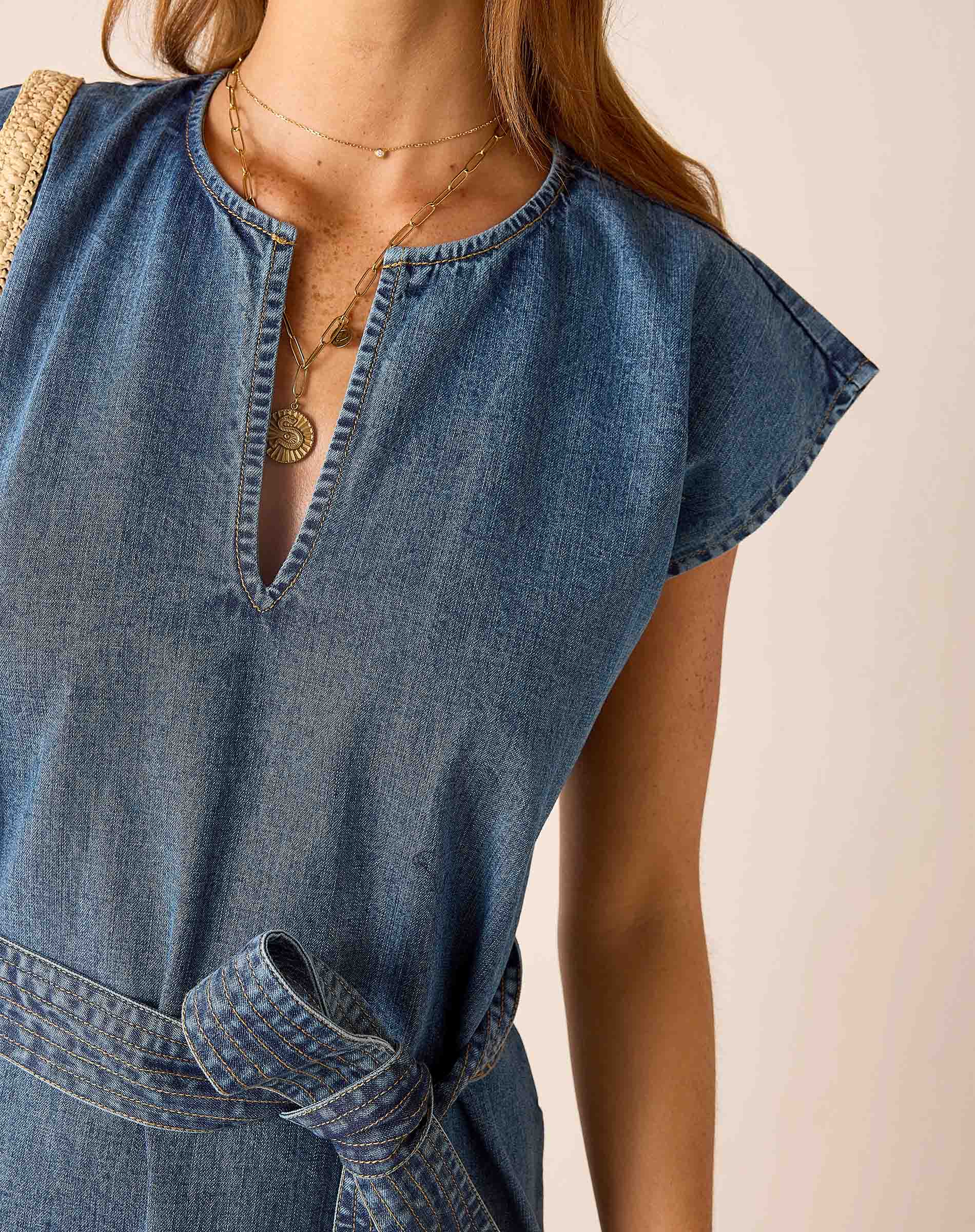 Denim dress worn by a person on a plain background