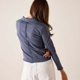 Atlas blue long sleeve polo tee with a ruffled detail along the back seam