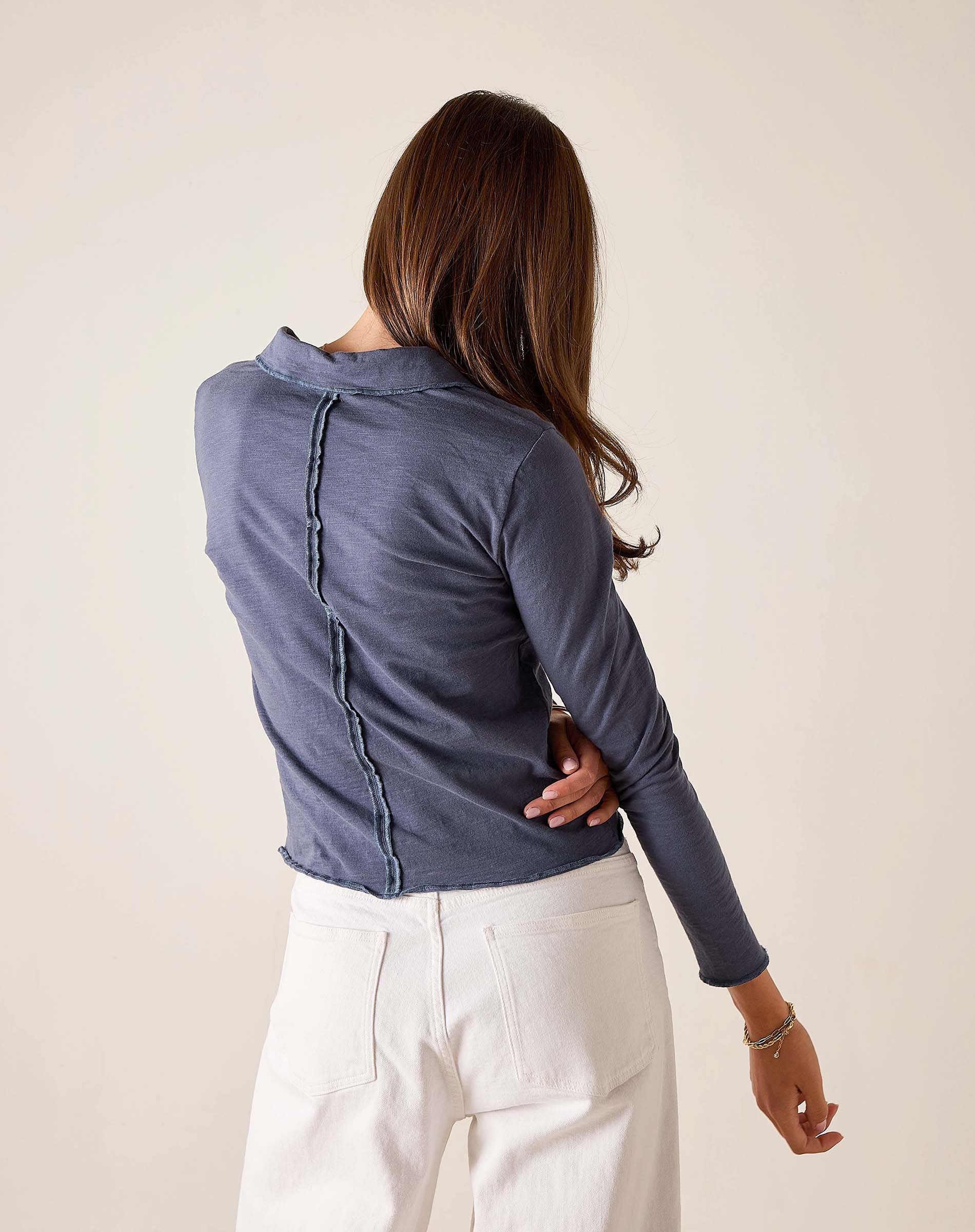 Atlas blue long sleeve polo tee with a ruffled detail along the back seam