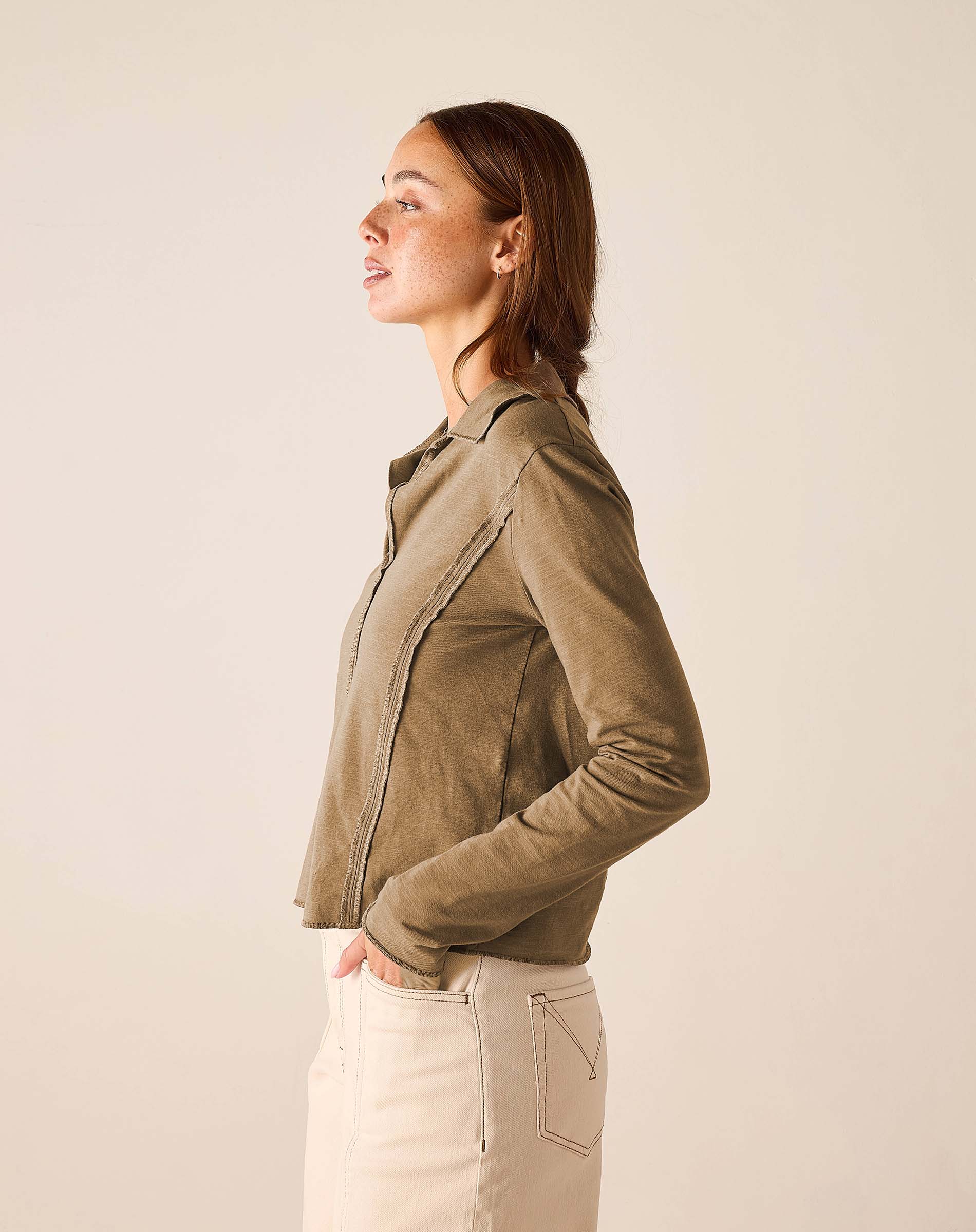 Nutmeg colored knit polo tee with a buttoned collar and zip front detail.