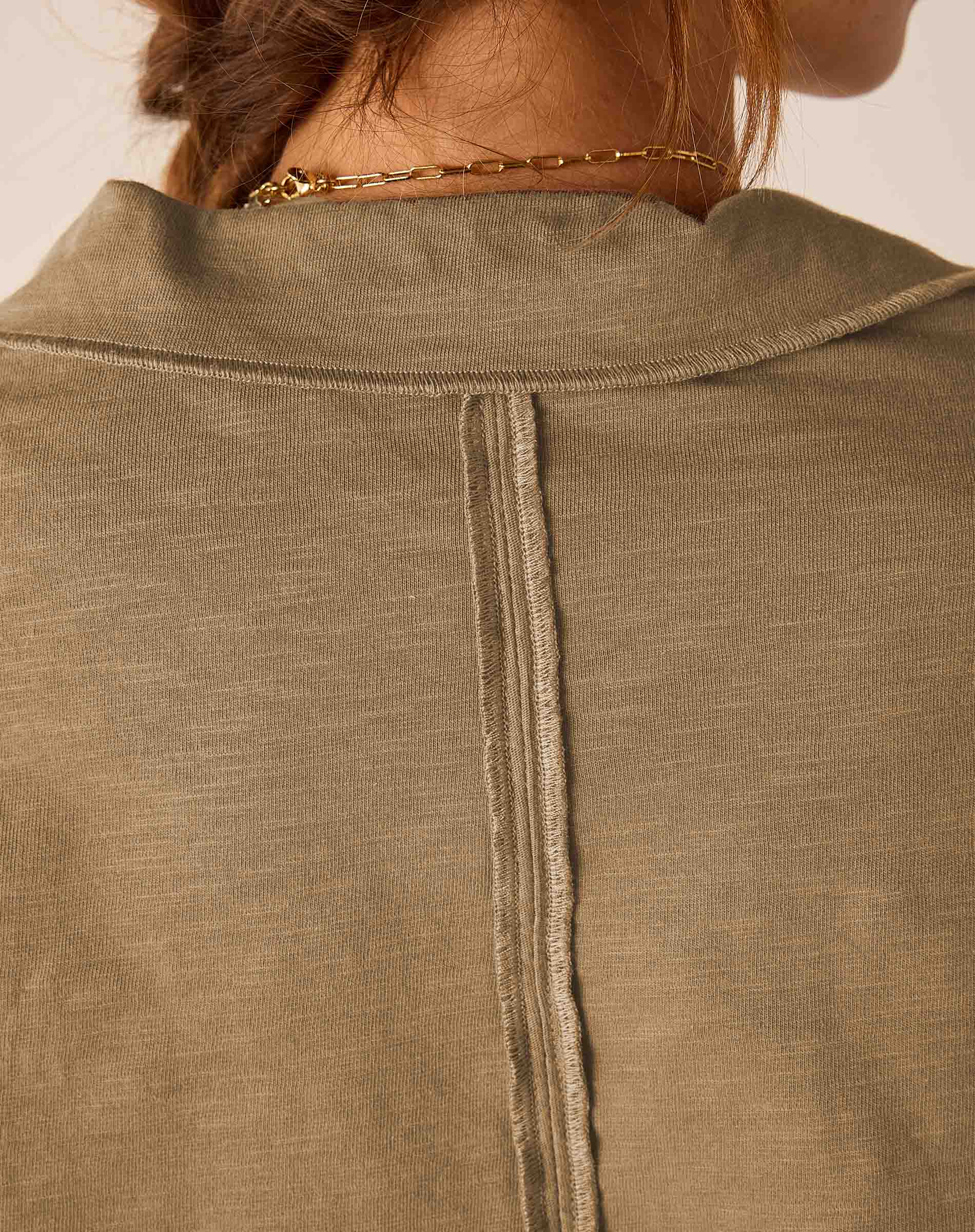 Nutmeg colored ribbed knit polo tee with a high neck and buttoned placket.