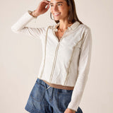 White ribbed knit polo tee with a front zipper and pocket detailing.