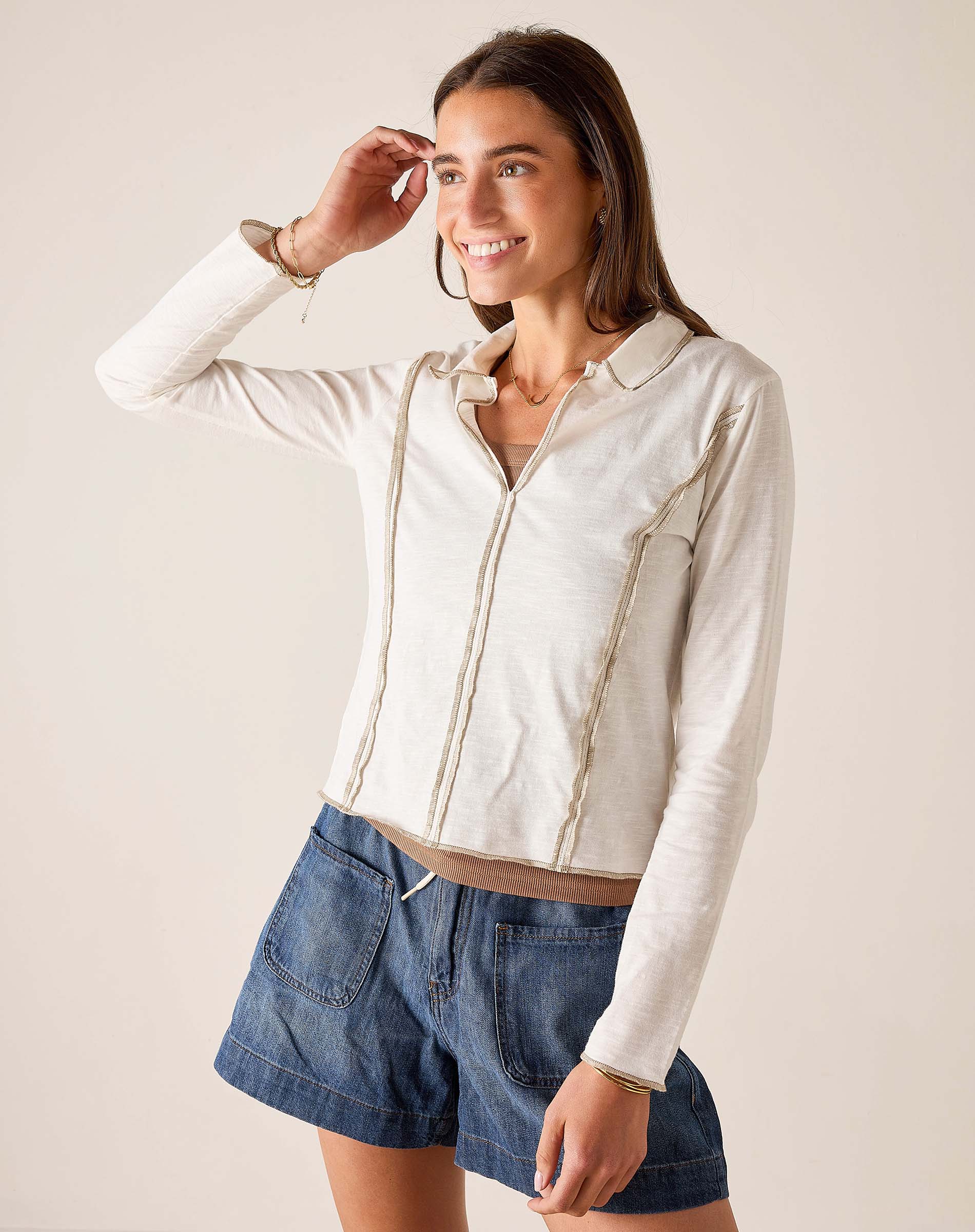 White ribbed knit polo tee with a front zipper and pocket detailing.