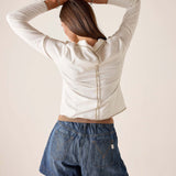 Back view of women's travel-friendly white ribbed cotton polo tee with a buttoned back and structured collar.