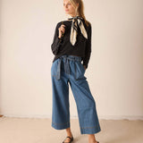 Women's travel-friendly graphite grey raglan tee with a graphic print and wide-leg denim trousers.