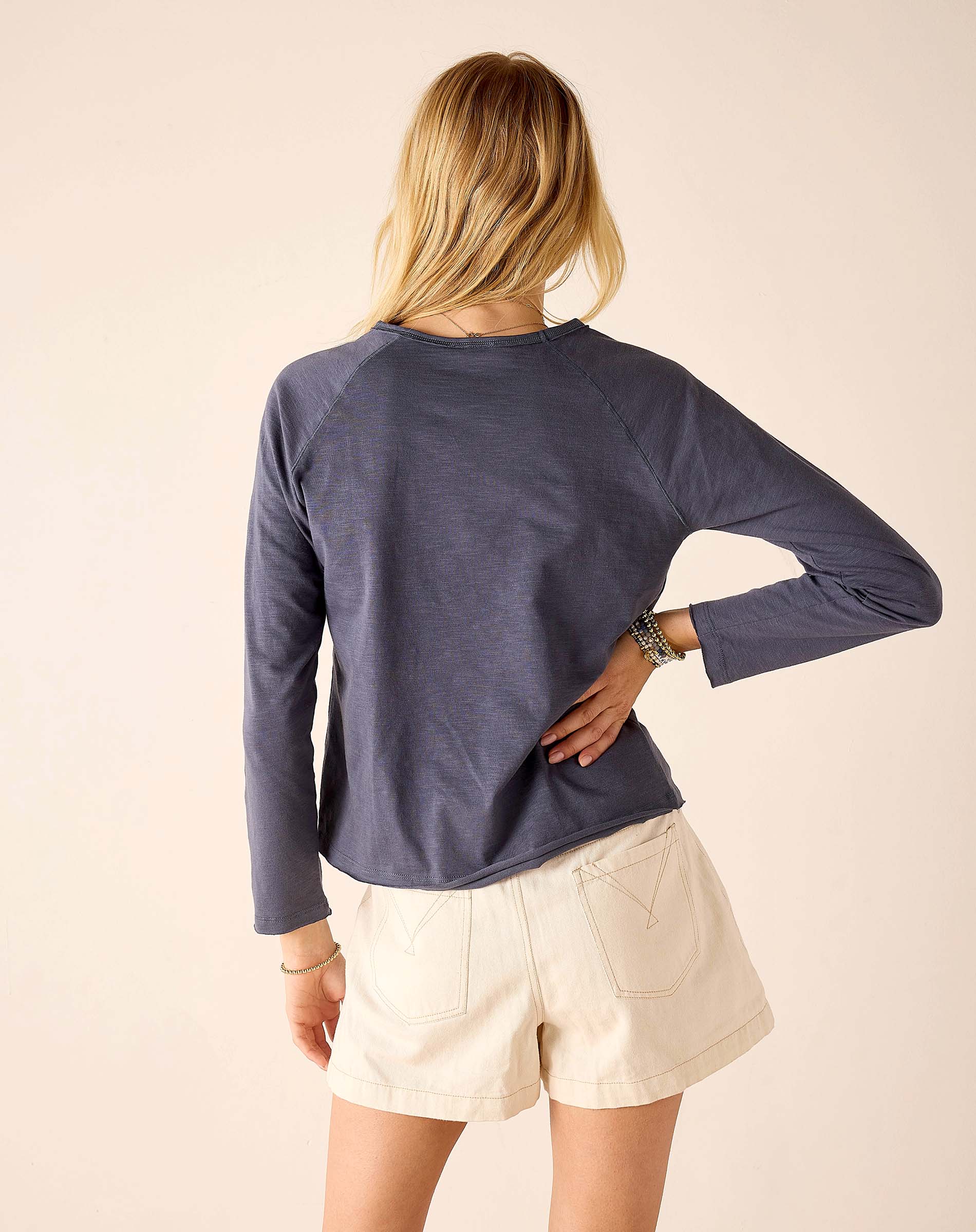 Back view of women's travel-friendly navy blue raglan tee in soft jersey fabric.