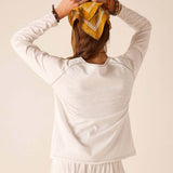 Back view of woman wearing a white raglan tee with soft cotton blend fabric.