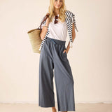 Women's travel-friendly white cotton tee with navy striped trim and atlas blue wide-leg pants.