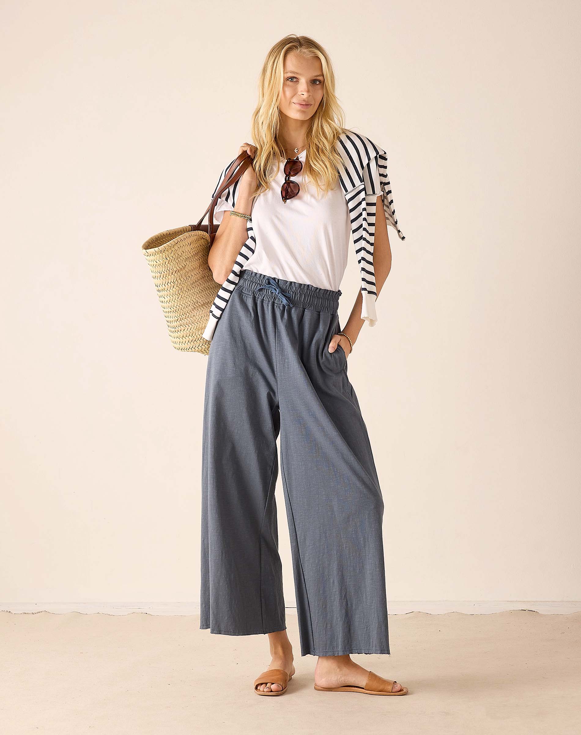 Women's travel-friendly white cotton tee with navy striped trim and atlas blue wide-leg pants.