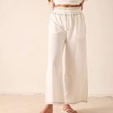 Off-white wide-leg pants in a lightweight woven fabric with an elasticated waistband and finished hems.