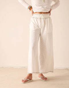 Off-white wide-leg pants in a lightweight woven fabric with an elasticated waistband and finished hems.