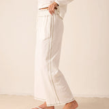 White wide-leg linen pants featuring a vertical seam detail.